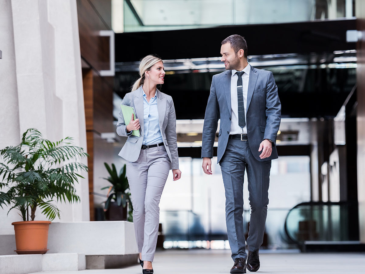Two business people walking through office